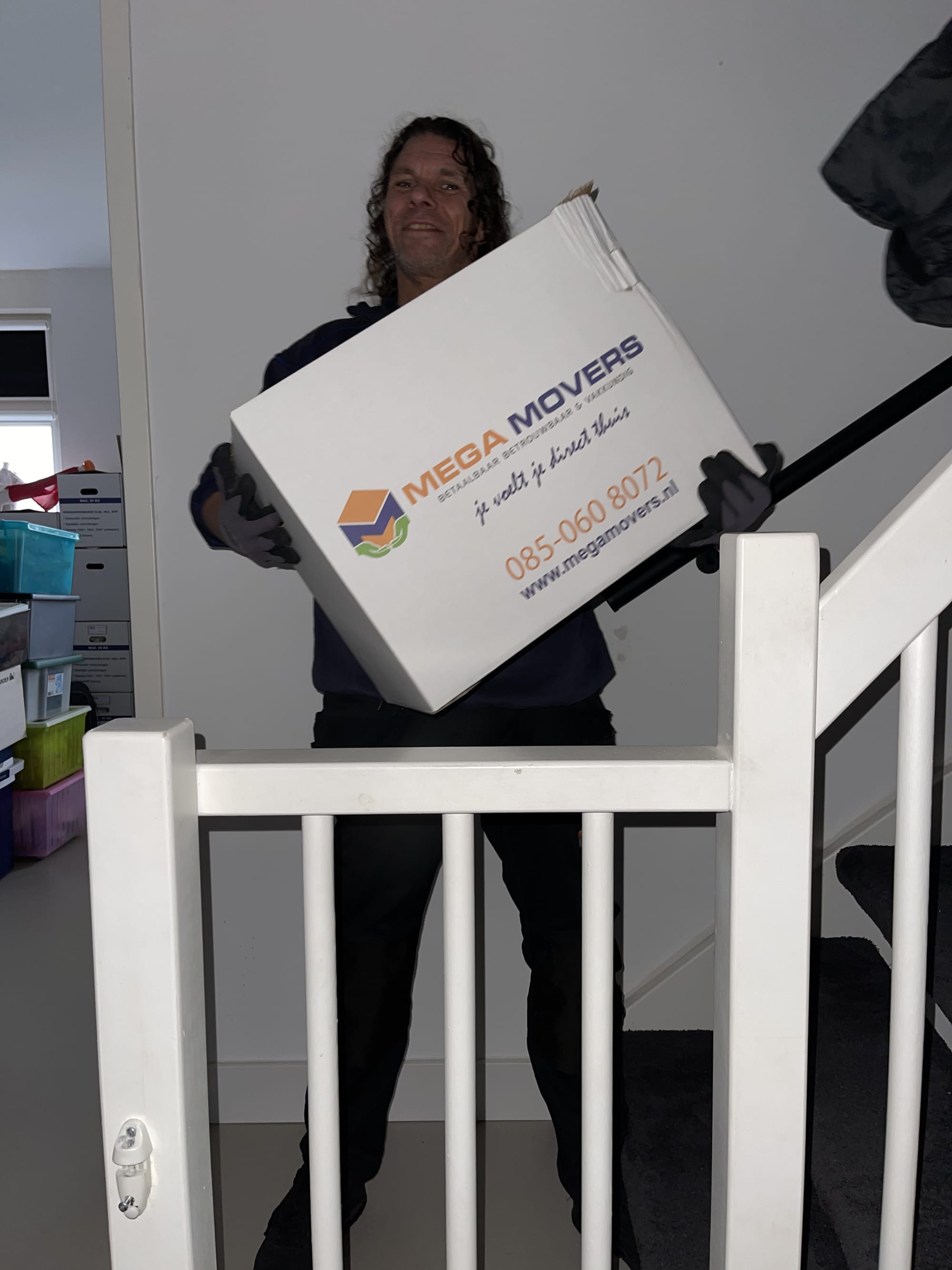 Verhuizer draagt een Mega Movers verhuisdoos de trap op
