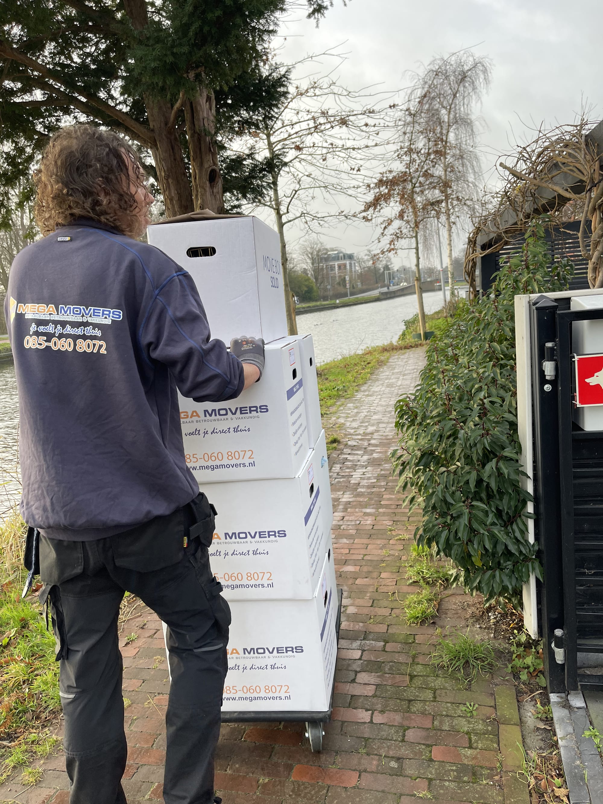 Verhuizer met Mega Movers verhuisdozen aan de waterkant