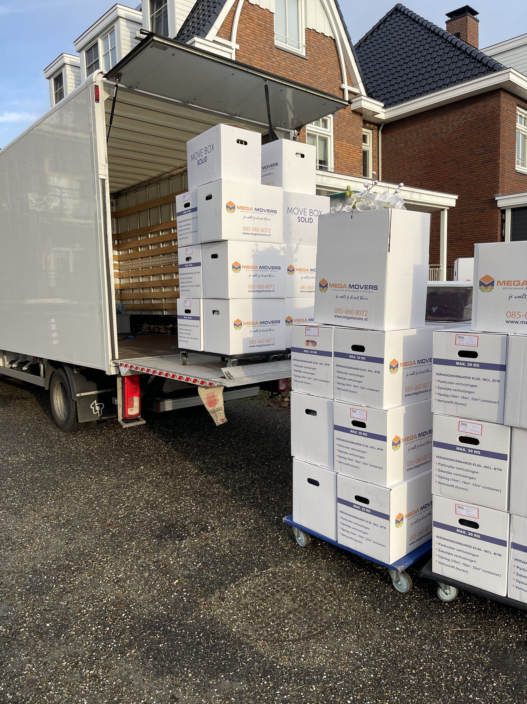 Volgeladen Mega Movers verhuiswagen met verhuisdozen