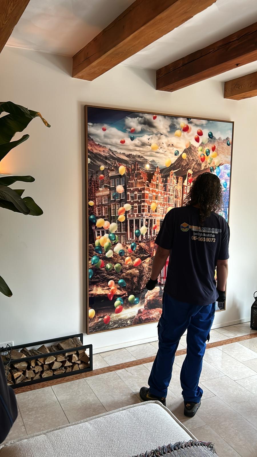 Verhuizer draagt voorzichtig een groot ingelijst kunstwerk