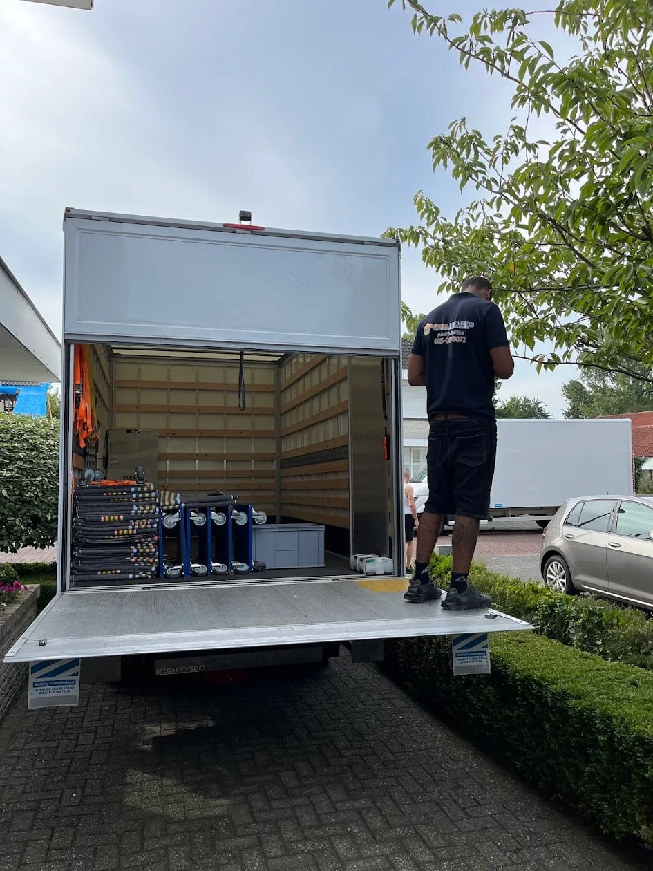 Verhuizer laadt materiaal in via de laadklep
